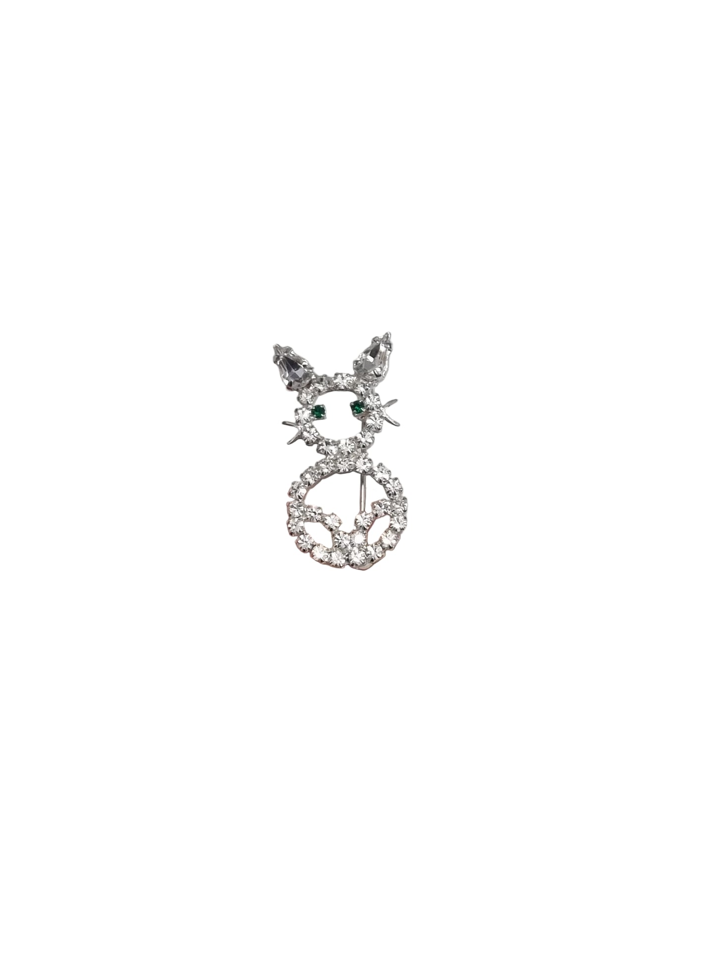Hand holding a silver cat brooch with gemstones