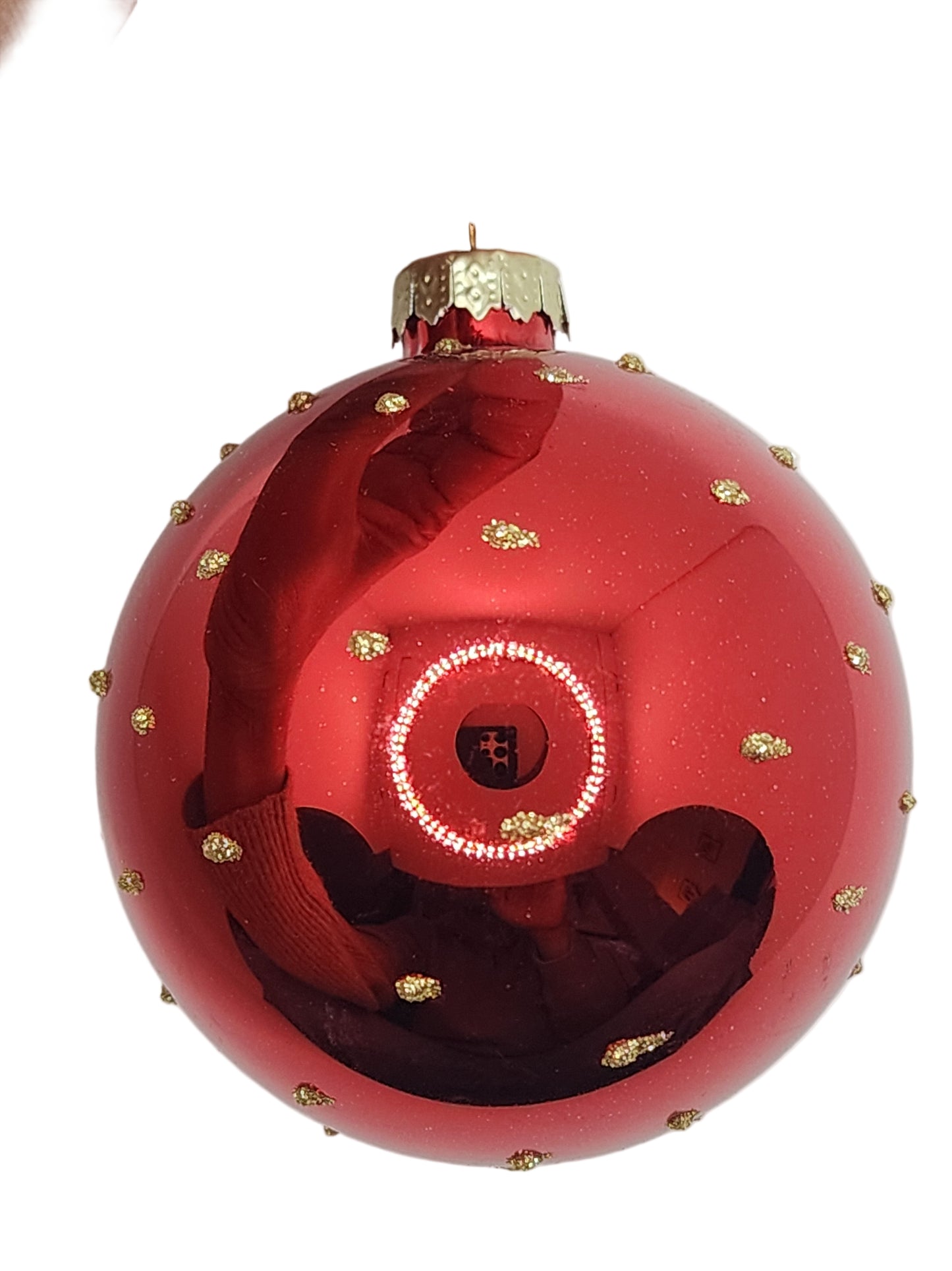 Red decorative ball with gold accents against a white background