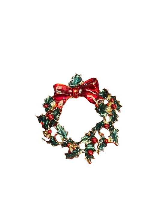 A red and green crystal brooch with glossy red bow