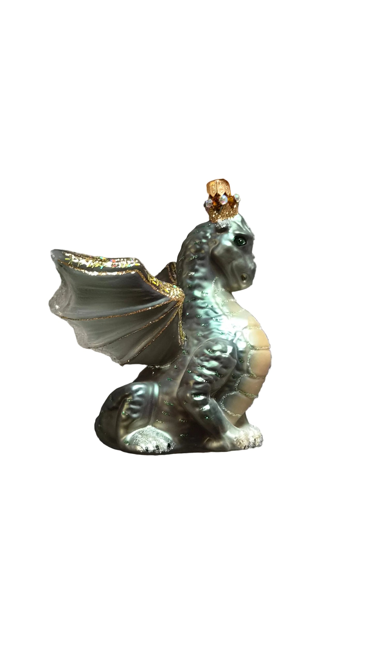 Decorative green glass christmas dragon ornament on a textured surface