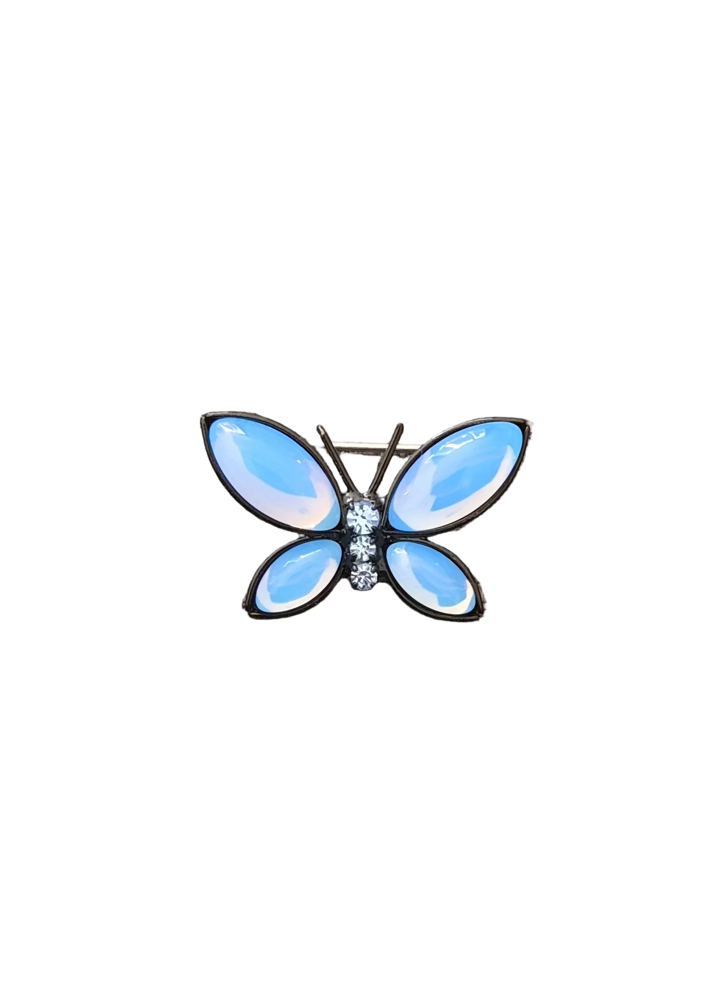 A butterfly-shaped brooch with light blue iridescent enamel wings and a small cluster of clear rhinestones at the center.