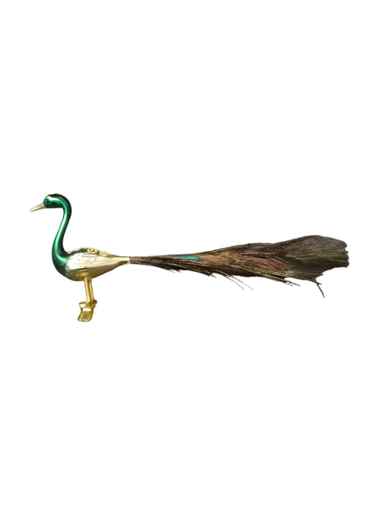 A decorative peacock figurine with a green neck, gold body, and peacock tail feathers
