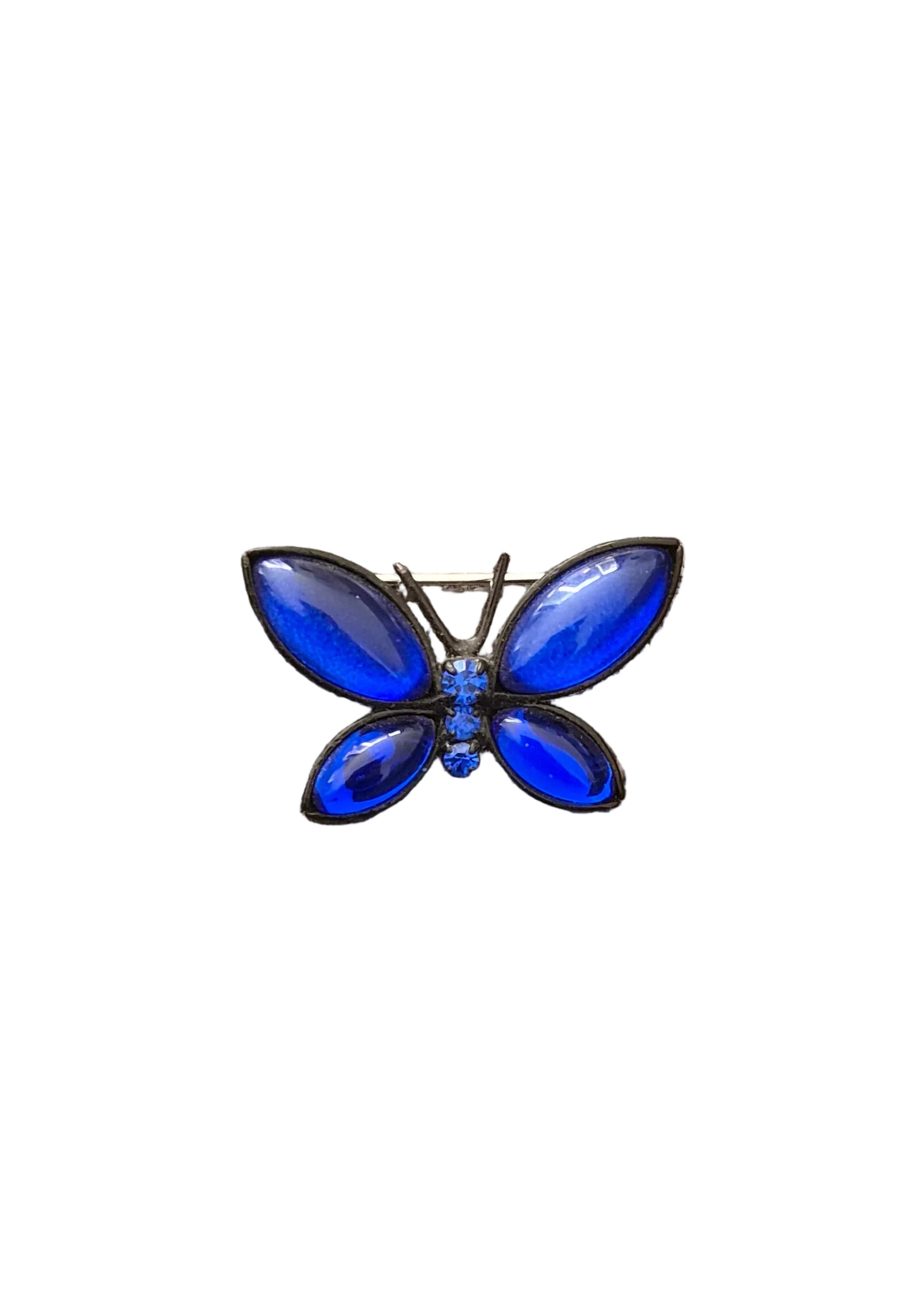 A butterfly-shaped brooch with vibrant blue rhinestone wings and a small blue center, set in a silver-tone metal.