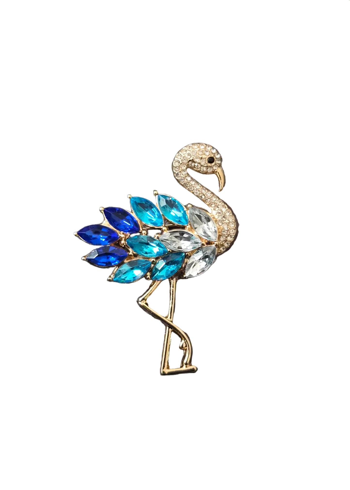 A flamingo-shaped brooch with a gold-tone body, a cream-colored neck and head, and a fan of marquise-cut crystals in shades of blue, royal blue, and clear,.