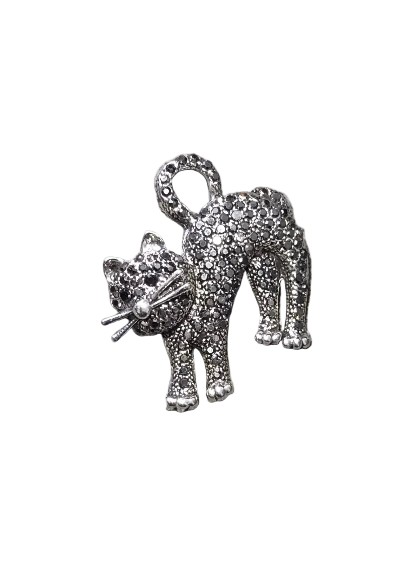 A silver-toned cat-shaped brooch or charm covered in small clear rhinestones, shown on a plain white background